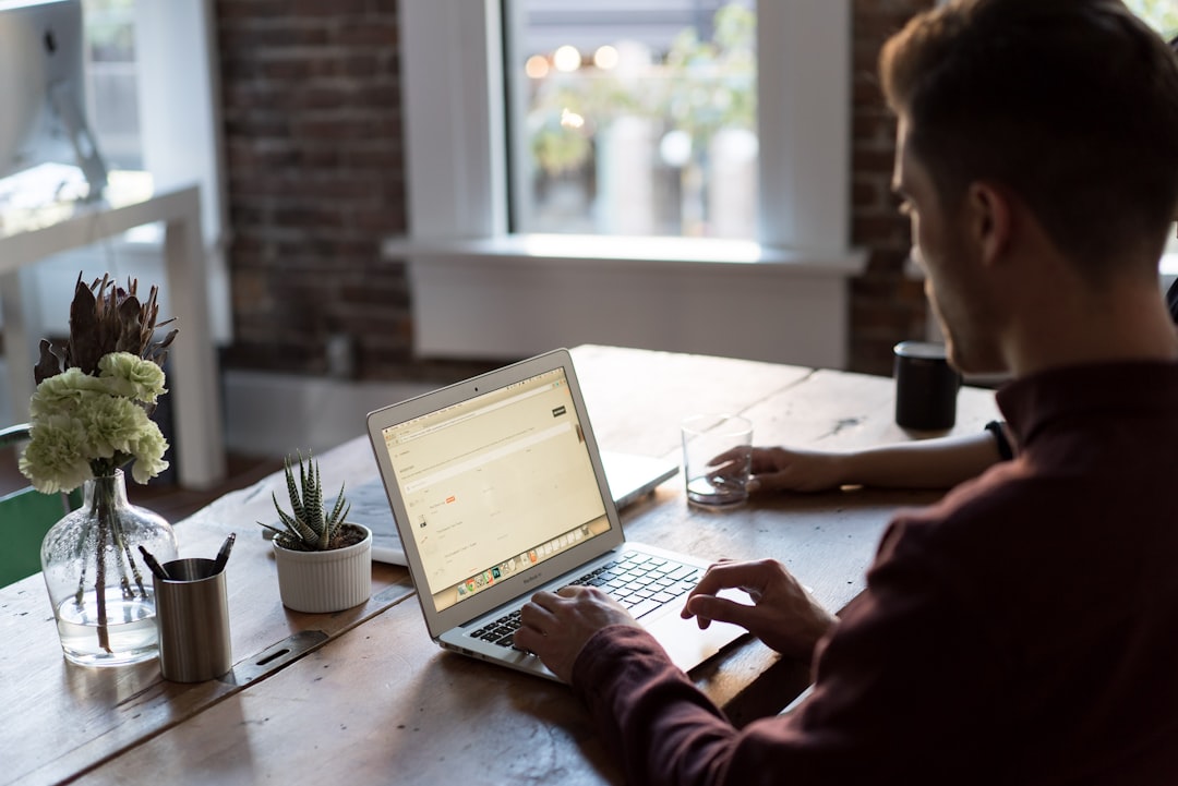 Man at a laptop in an office by Why Pi man operating laptop on top of table